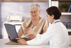 Senior looking at a laptop while talking to a doctor